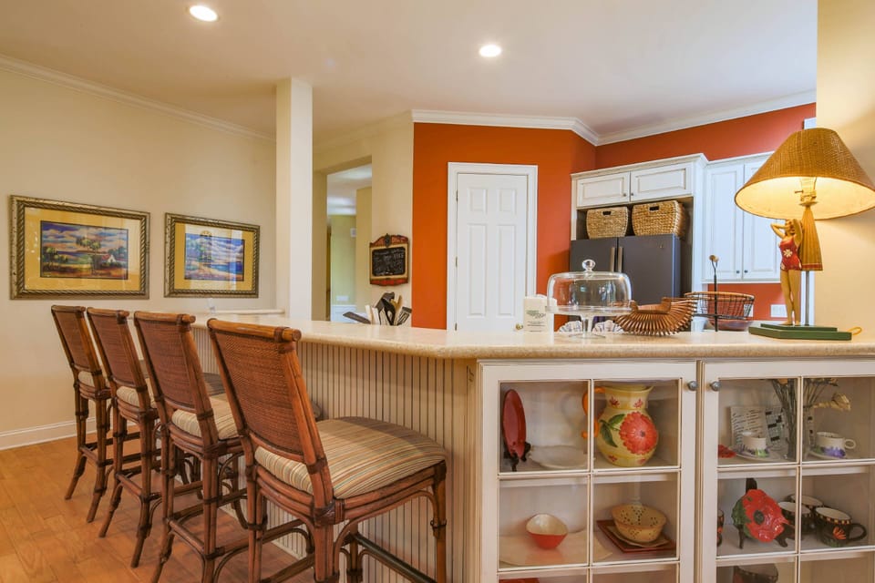 There are four high top stools at the kitchen counter.