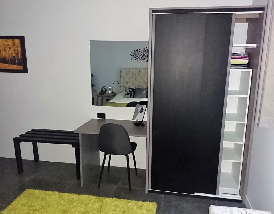 The main bedroom has a spacious wardrobe, dressing table and suitcase bench