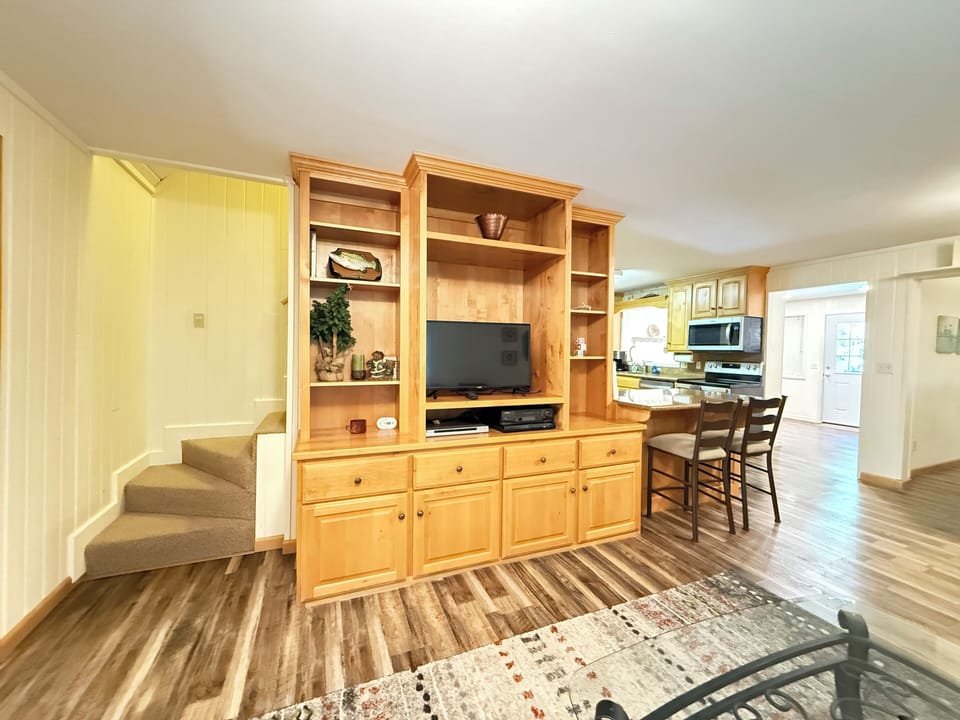 Large, comfortable furniture is arranged around a central focal point of the television.