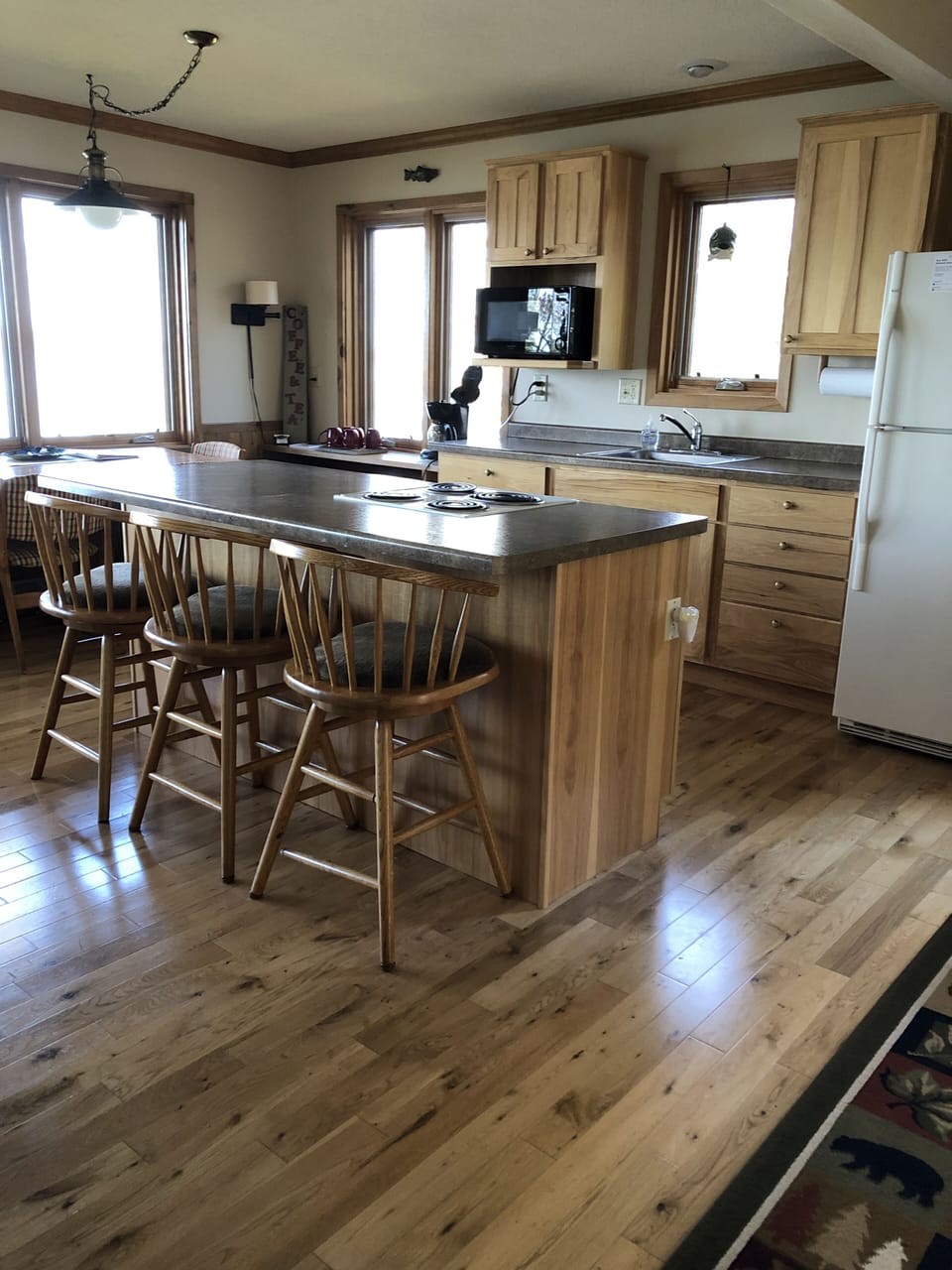 Fully-stocked kitchen with refrigerator, range/stove, microwave and sink.