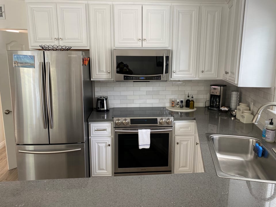 Kitchen with microwave, oven, glass top stove, fridge with ice maker, dishwasher