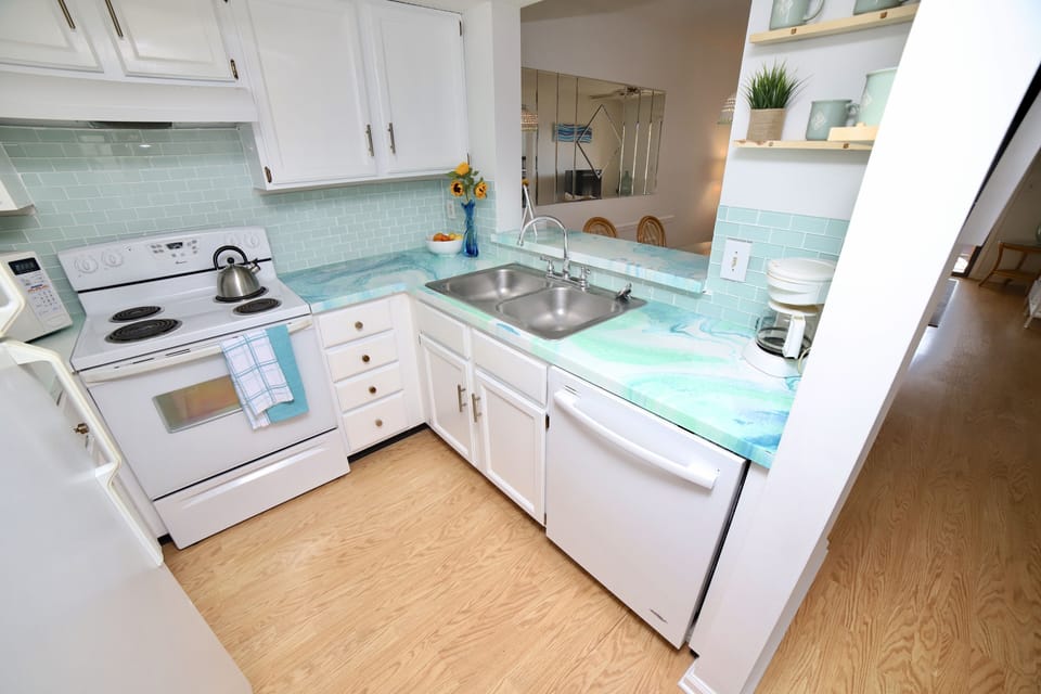 Aquamarine tiles & custom wave-themed countertops makes cooking on vacation fun!