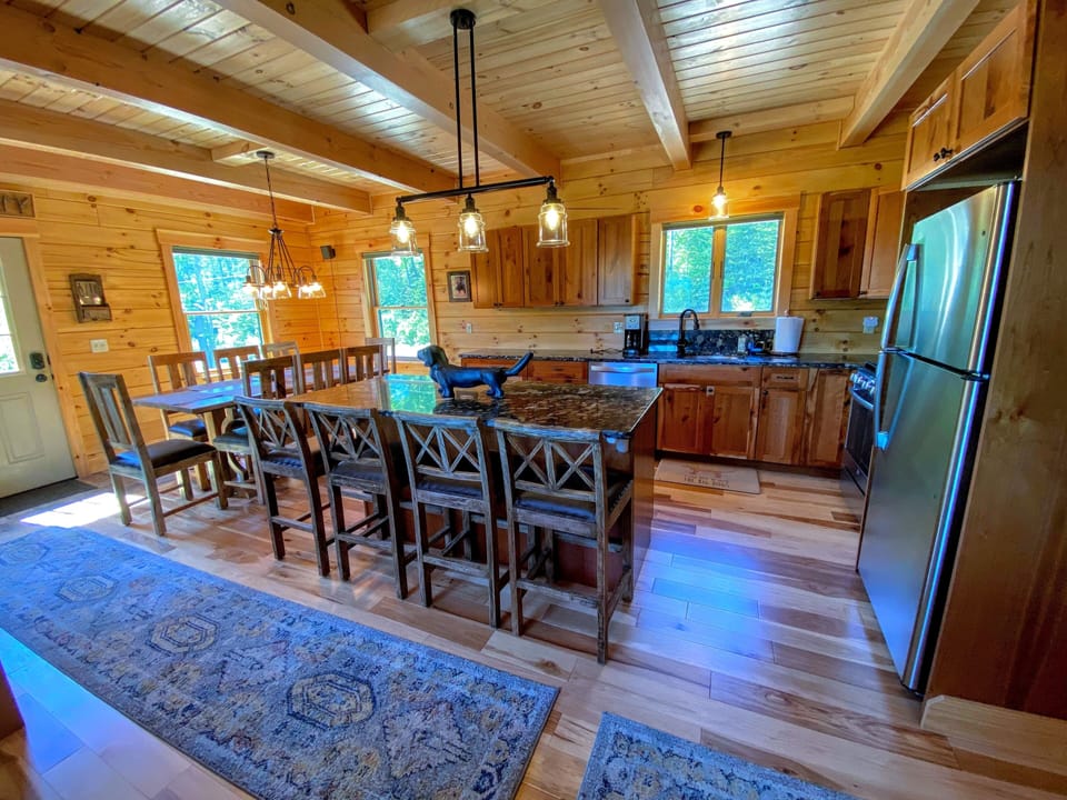 The kitchen, featuring sleek stainless steel appliances and elegant River Rock granite countertops, offers a perfect balance of sophistication and rustic warmth