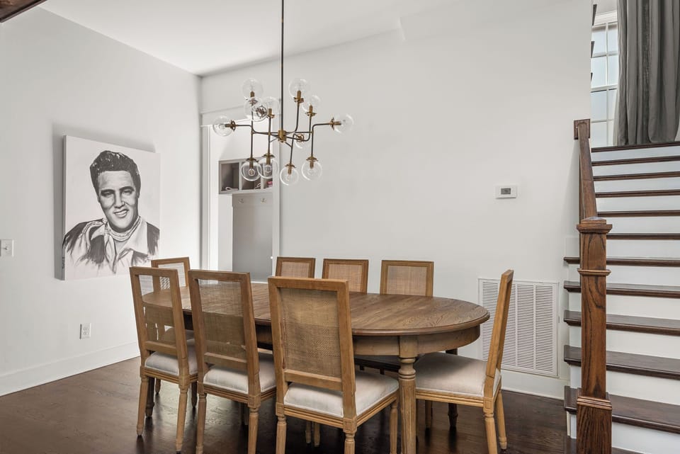 - Gather around this warm dining area with a wood table and classic chairs   - Unique chandelier lighting adds charm to every meal   - Clean design and bright walls create a comfortable dining experience