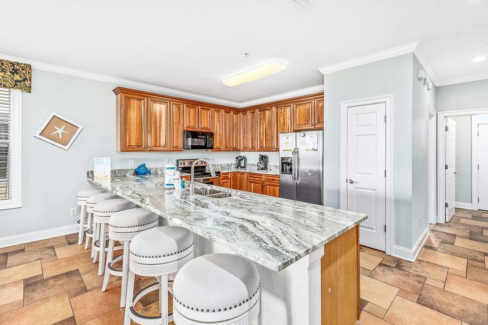 Your spacious kitchen features rich wood cabinets, stunning granite countertops, and a breakfast bar where you can enjoy morning coffee.