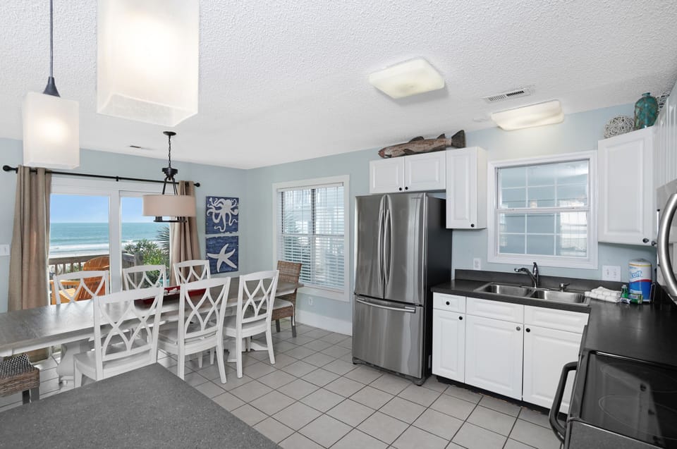 Your ocean-view kitchen invites coastal cooking with stainless steel appliances and stunning sea views through every window.