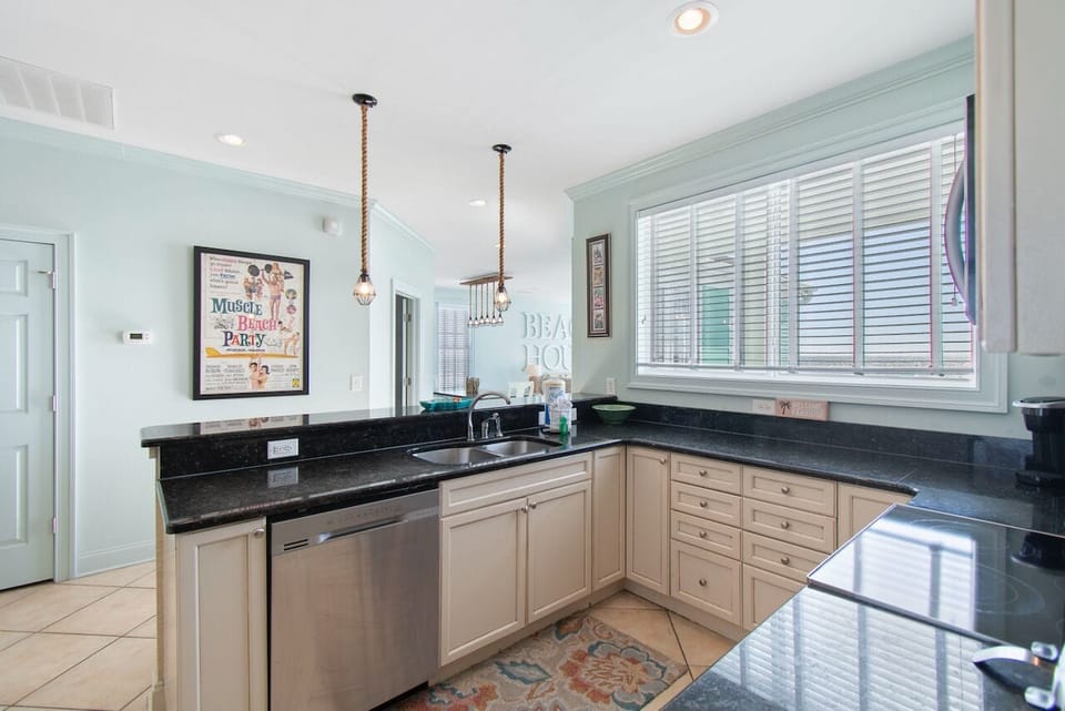 Your fully equipped kitchen features sleek granite counters and stainless appliances, perfect for preparing meals with that coastal charm.