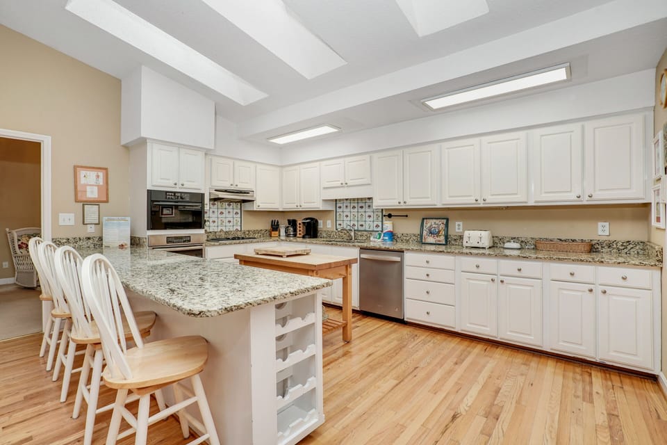 Your spacious kitchen features granite countertops, white cabinetry, and a breakfast bar where you can enjoy morning coffee.