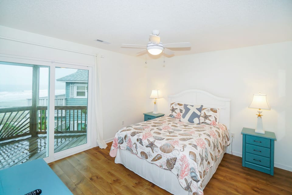 Wake to ocean breezes in your coastal bedroom featuring seashell bedding and calming teal accents.