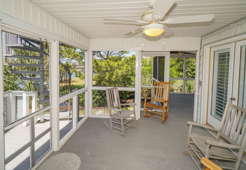 Unwind on your screened porch with rocking chairs and peaceful garden views, where gentle breezes and natural light create the perfect retreat.