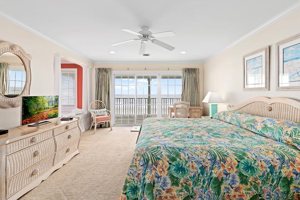 Relax in this tropical paradise bedroom with vibrant bedding, wicker furnishings, and your private balcony overlooking endless views.