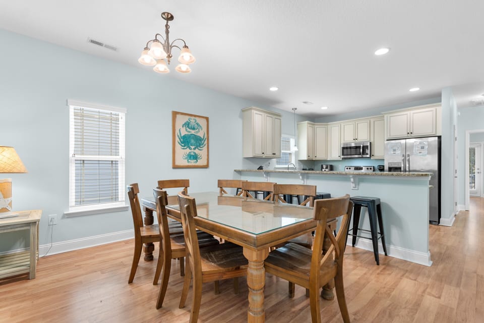 Your open-concept dining and kitchen space features coastal charm with warm wood tones, granite counters, and cheerful sea-themed decor.