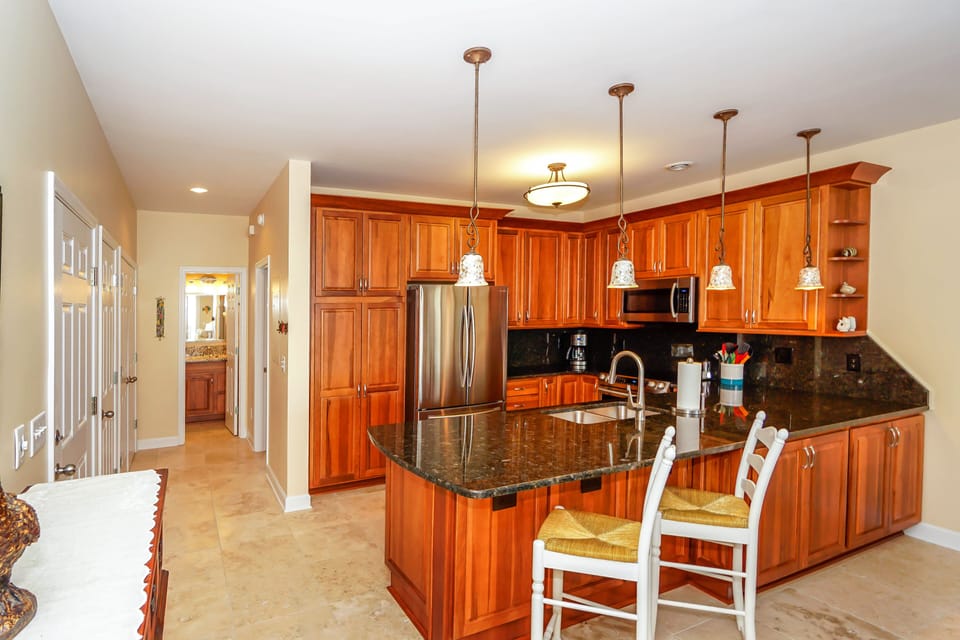 Your gourmet kitchen awaits with rich cherry cabinets, granite counters, and stainless steel appliances—perfect for creating memorable meals together.