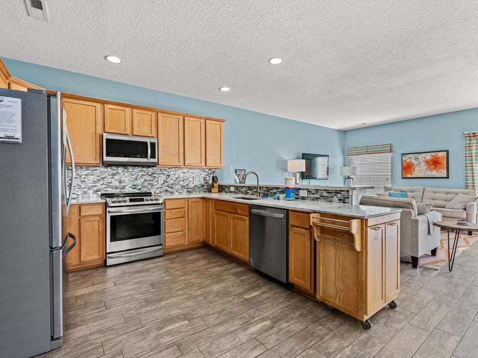 Your fully equipped kitchen features granite counters, stainless appliances, and a breakfast bar perfect for casual dining.