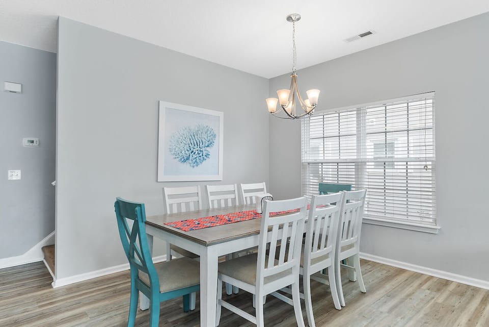 Gather around this elegant dining table where memorable meals and conversations unfold under warm chandelier lighting in your serene dining space.