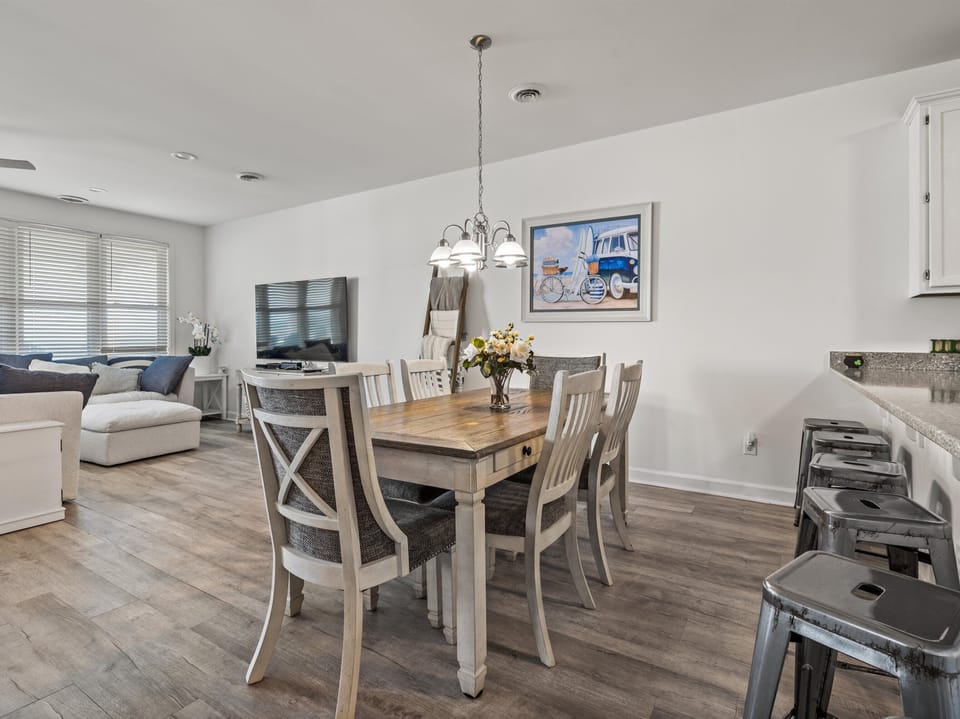 Gather around your elegant dining table where fresh flowers welcome shared meals and laughter in this bright, open living space.