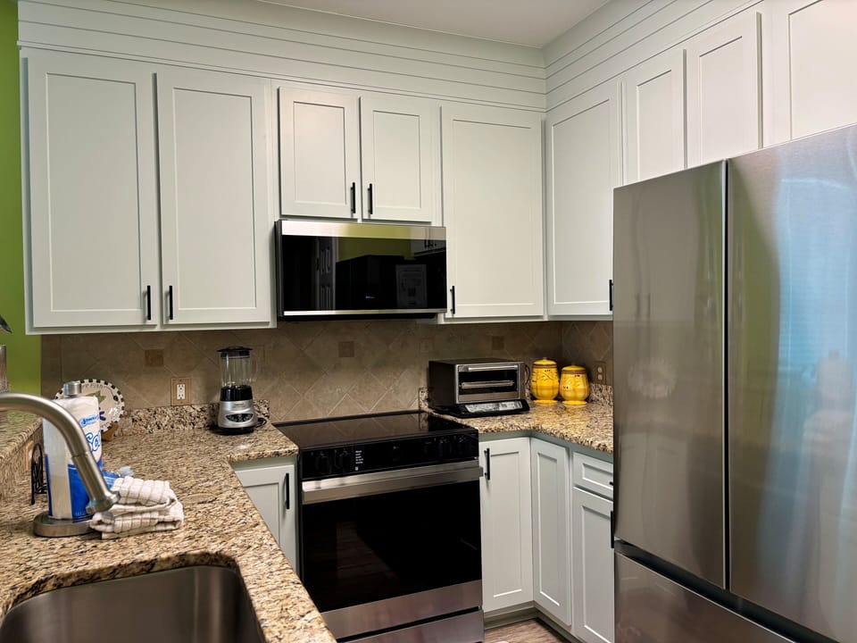 Your fully equipped kitchen features granite countertops, stainless steel appliances, and white cabinets for all your cooking needs.