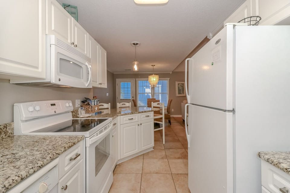 Your fully equipped kitchen features granite countertops, white cabinets, and all the appliances you need for home cooking.