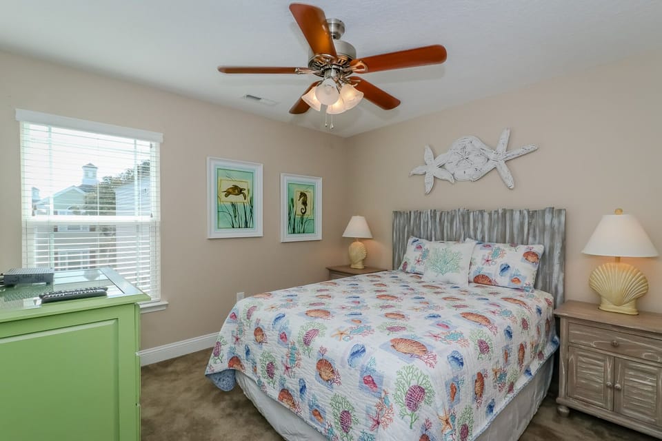 Drift off to coastal dreams in your bright bedroom, complete with nautical decor and a gentle ceiling fan for comfort.