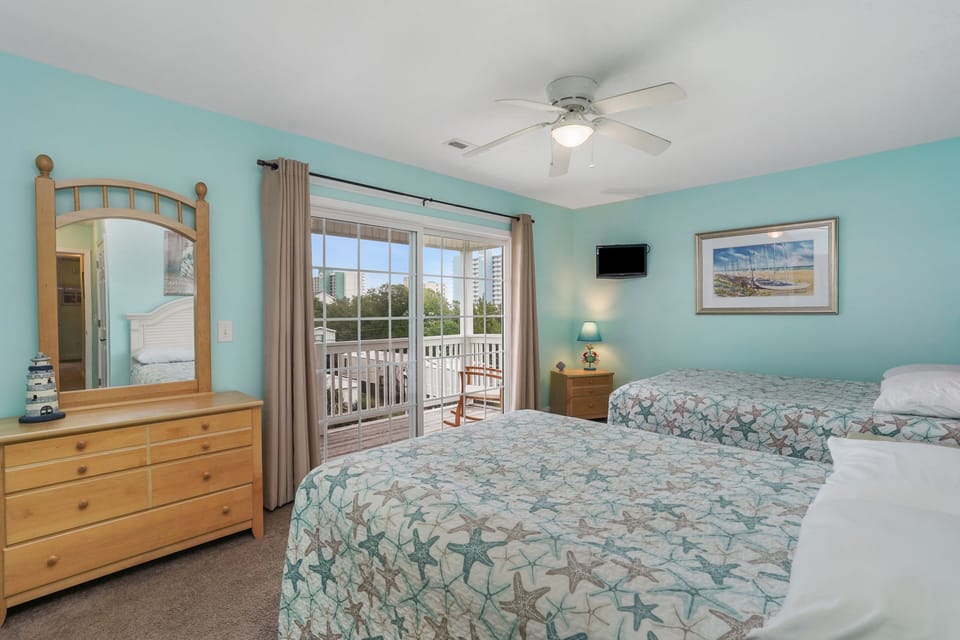 Wake up to ocean-themed comfort in your bright bedroom featuring twin beds and private balcony access for morning coffee moments.
