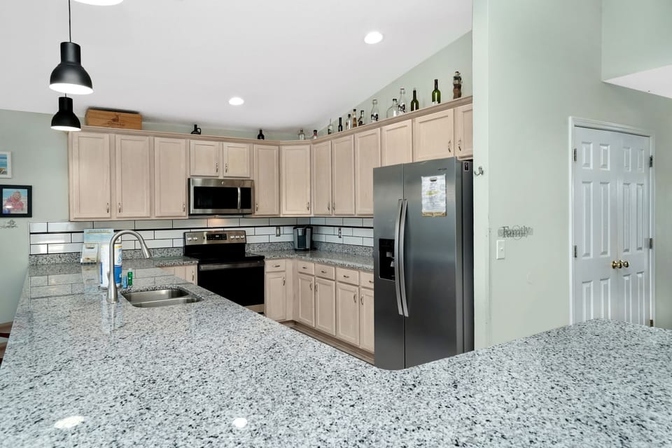 Your spacious kitchen features granite countertops, stainless steel appliances, and ample cabinet storage for preparing memorable meals together.
