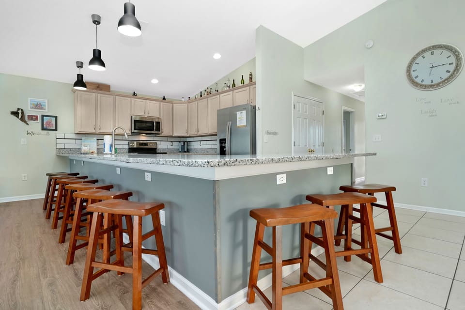 Gather around this spacious kitchen island with granite counters and modern appliances for memorable meals together.