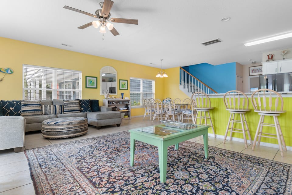 Relax in your vibrant, open-concept living space featuring colorful decor, comfortable seating, and a cheerful dining area perfect for gathering.