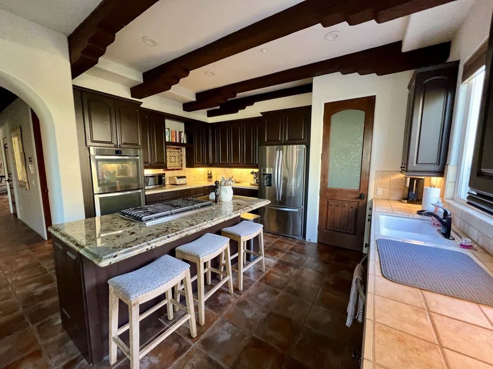 Step into a chef's paradise w/ this stylish, well-appointed modern kitchen w/ bar seating for three. Featuring stainless steel appliances, sleek countertops, & ample cabinet space, it's the perfect space to cook creating delicious memories together.