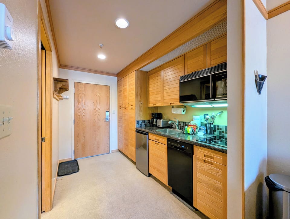 Your fully-equipped kitchen features warm wood cabinetry, granite counters, and modern appliances for creating memorable meals during your stay.