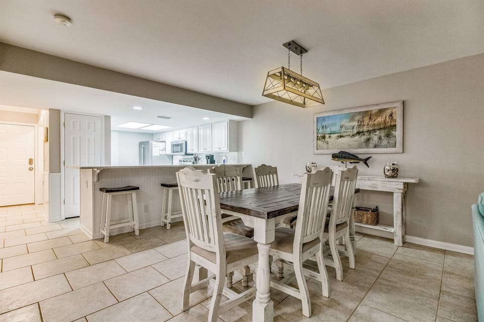 Dining table with seating and coastal décor at Wind Drift Orange Beach