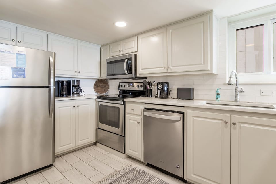 White kitchen with stainless appliances at Wind Drift Orange Beach
