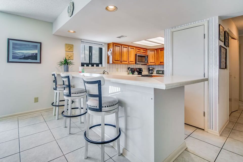 Open dining and living area with Gulf views at Wind Drift Orange Beach