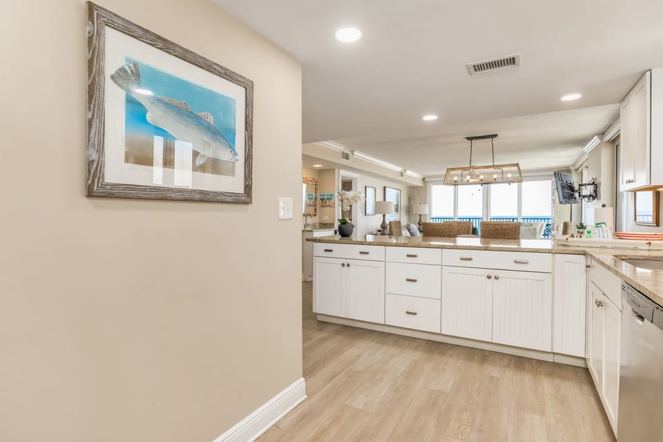 White cabinetry kitchen with granite counters at Wind Drift Orange Beach condo