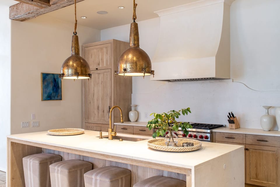 Kitchen Island with Stools, Refrigerator, and Ceiling Lamps.