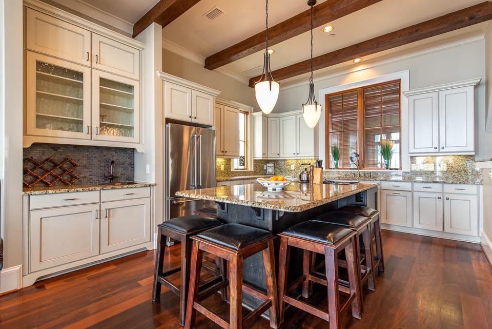 Kitchen Island with Stools, Refrigerator, and Wet Bar.
