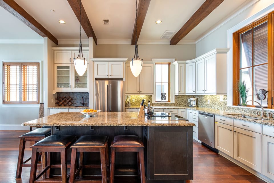 Kitchen Island with Stools, Refrigerator, and Dishwasher.