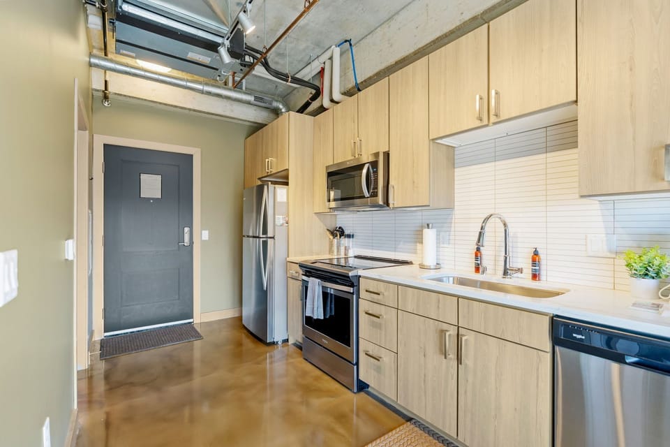 Your modern kitchen features sleek wood cabinetry, stainless steel appliances, and stylish industrial touches that create the perfect space for cooking.
