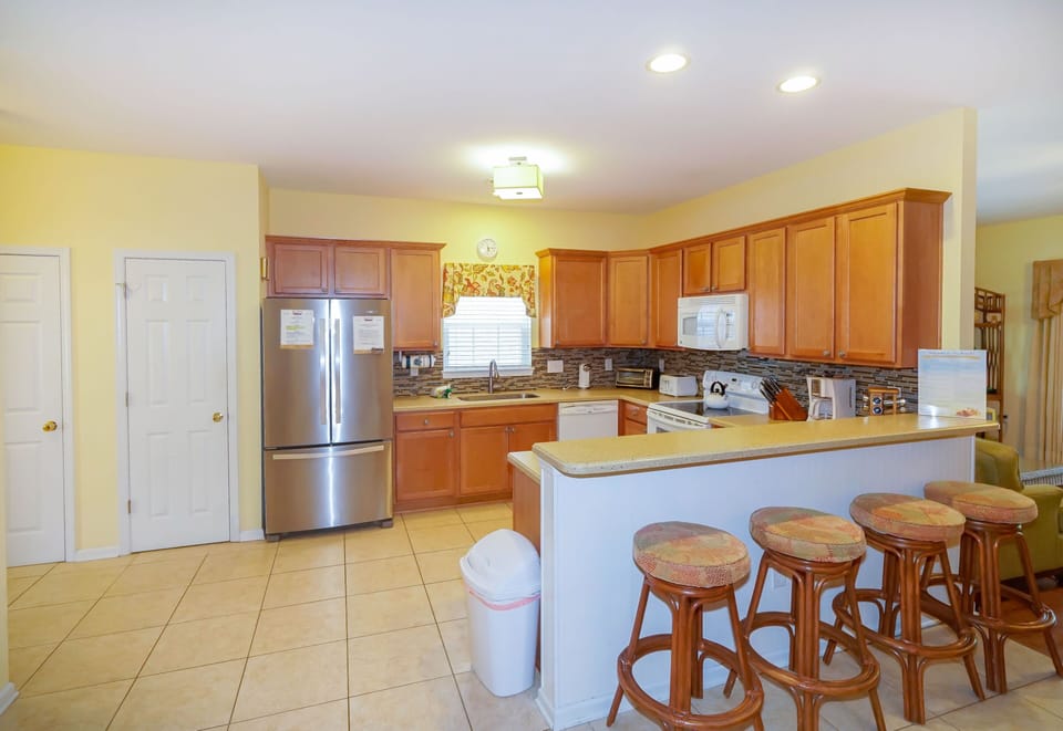 Your spacious kitchen awaits with warm wood cabinets, granite counters, and a breakfast bar where you can sip morning coffee.