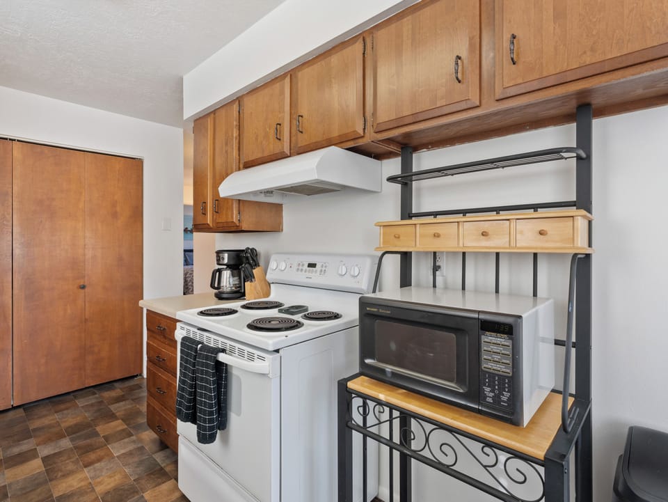 The kitchen is fully stocked with cookware, dishes, utensils and appliances.