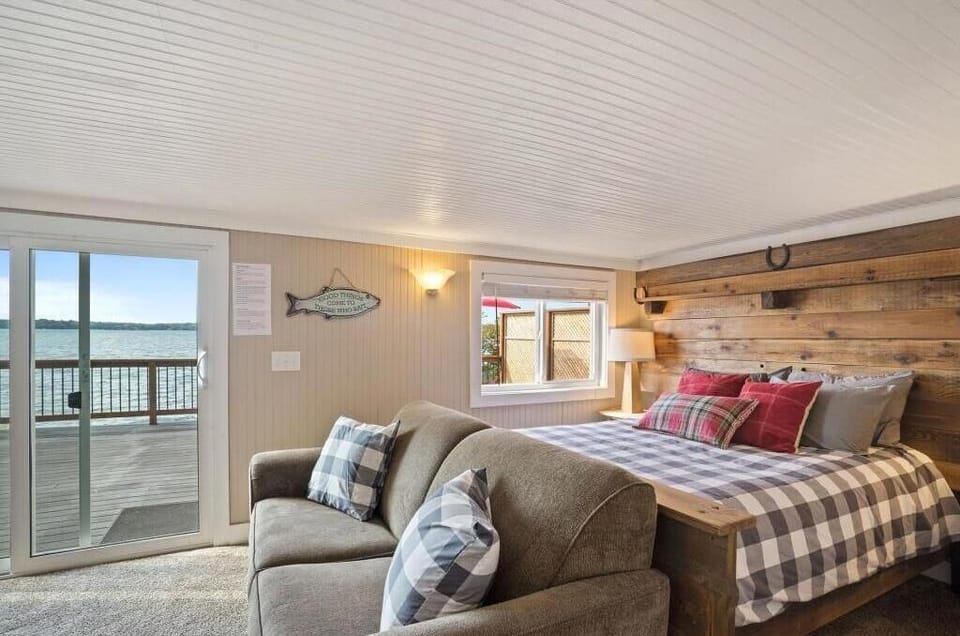 Lower level bedroom with sliding door to deck and small sitting area with a TV.