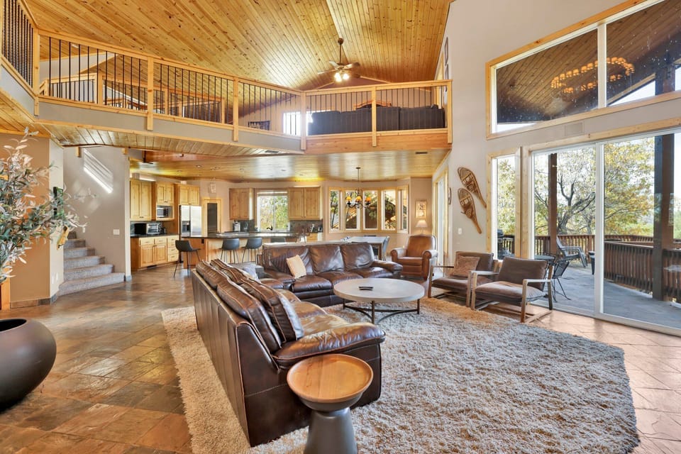 Cozy mountain living room with a stone fireplace, comfy seating, and smart TV—perfect for relaxing evenings, movie nights, and warm cabin vibes after outdoor adventures.