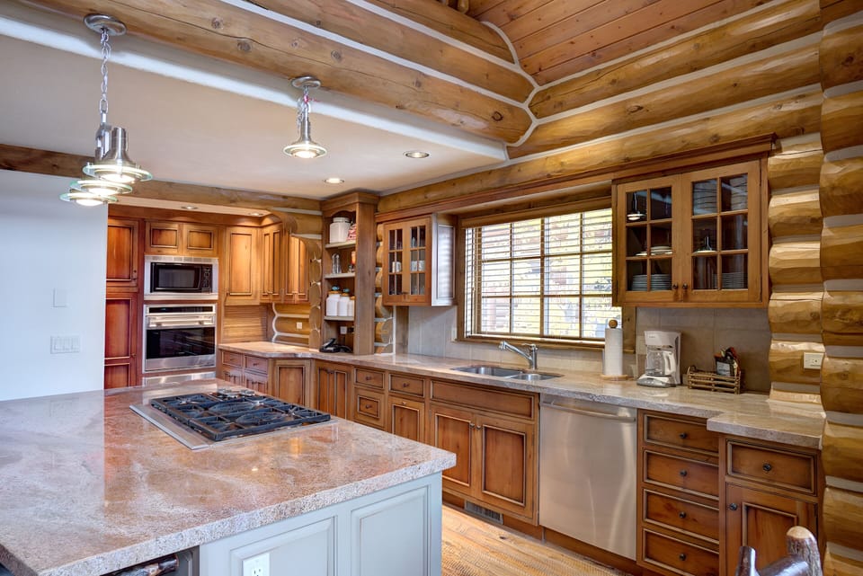 Cook together in a spacious gourmet kitchen with warm wood tones.
