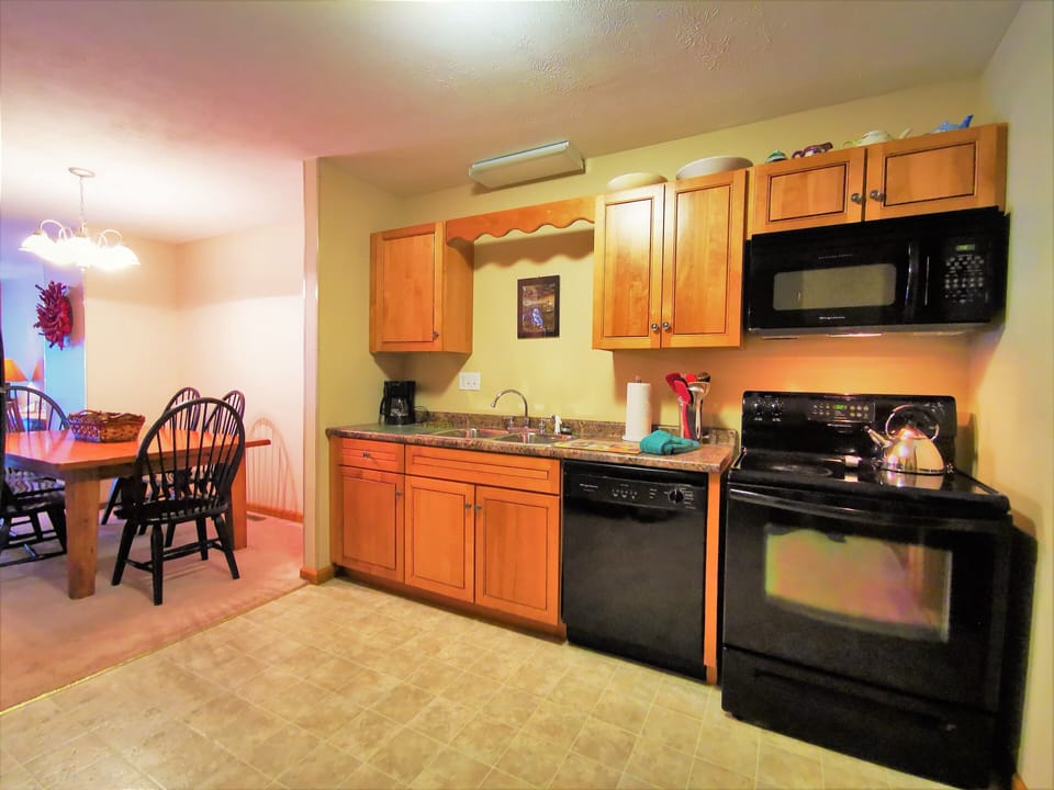 Modern kitchen with wooden cabinets and dining area nearby
