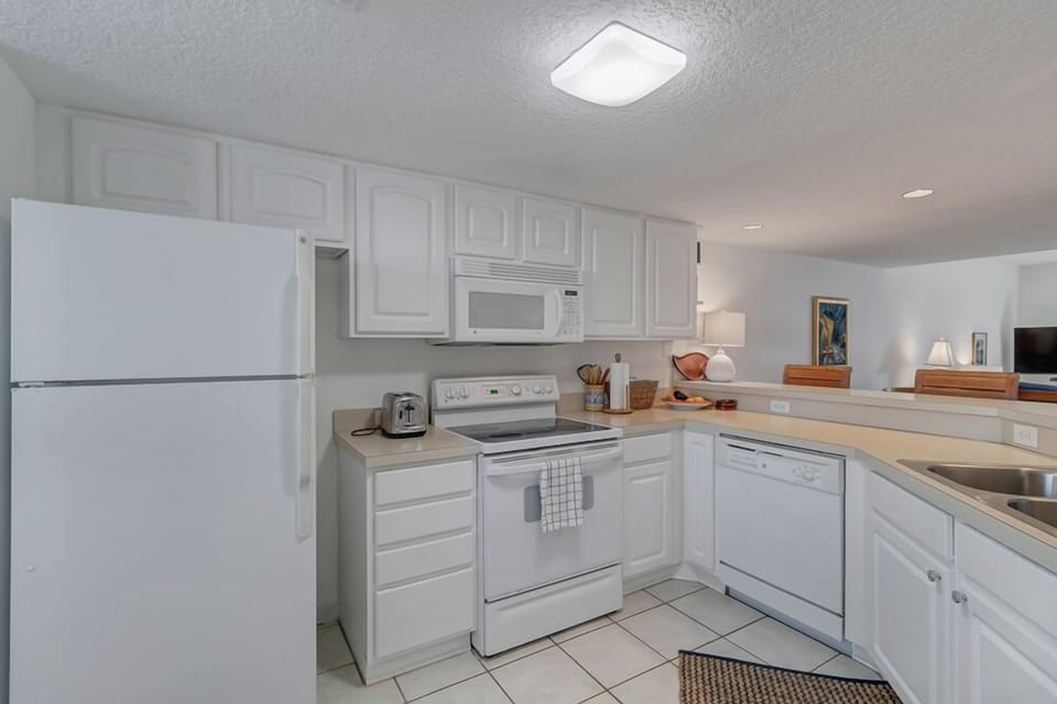 - Enjoy a bright and fully equipped kitchen with sleek white appliances and cabinets
- Open layout lets you cook and connect with guests at the same time
- Stove, dishwasher, microwave, and fridge all ready for your stay