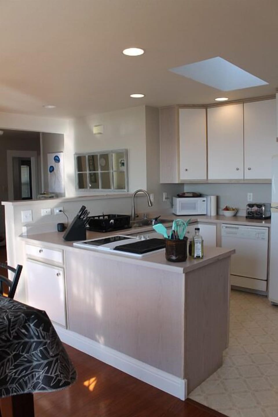Kitchen is compact and complete with spices, oils, pots, pans, coffee maker.