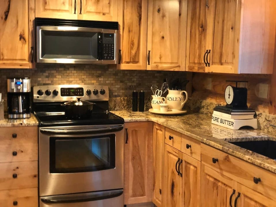 Cozy open concept kitchen with beautiful dishes and gourmet cookware.  