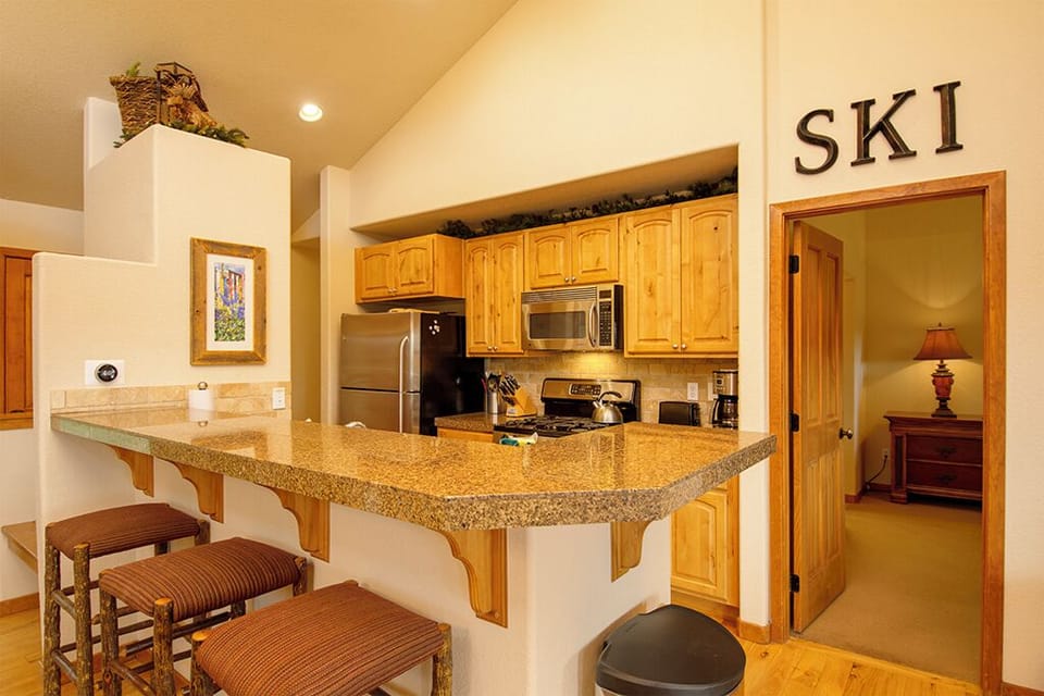 Your fully equipped kitchen features granite countertops, modern appliances, and a breakfast bar where you can enjoy morning coffee.