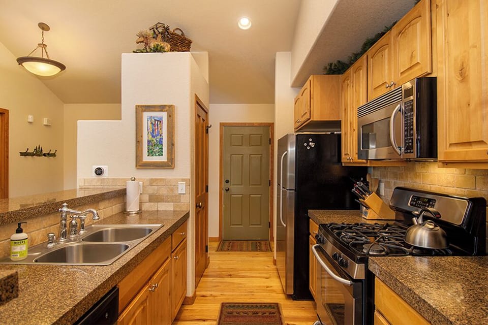 Your fully equipped kitchen awaits with granite counters, stainless appliances, and warm wood cabinets for memorable meal prep together.