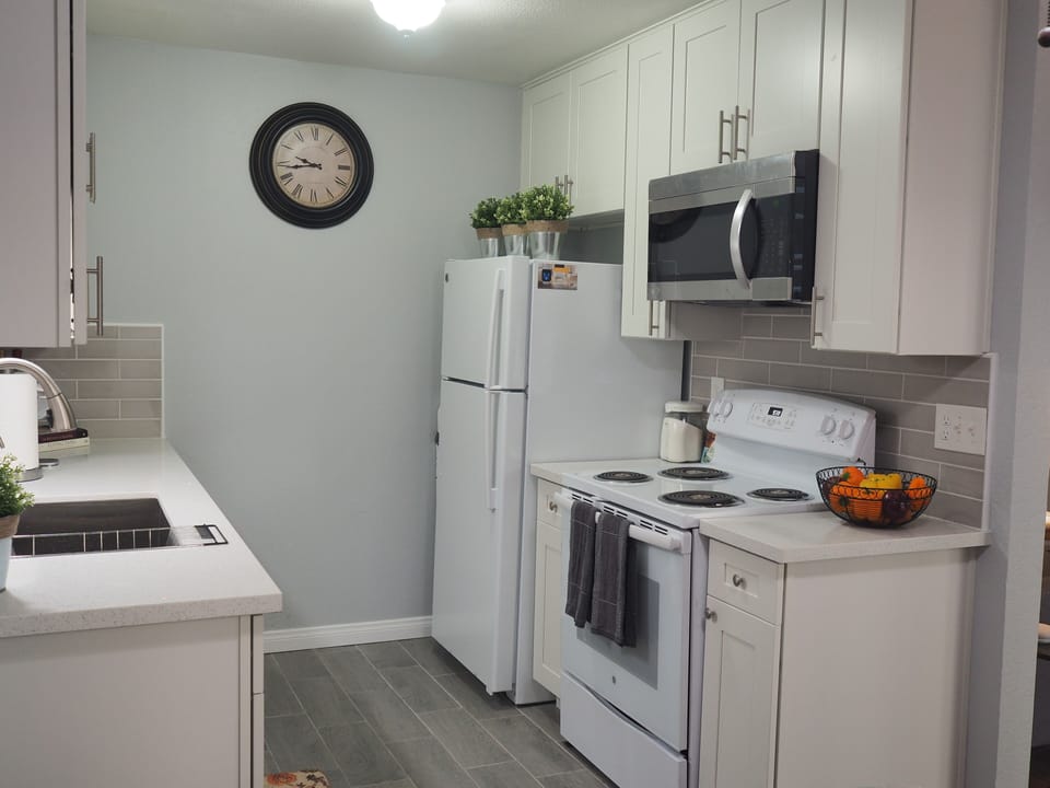 Kitchen fully equipped with cooking utensils and dishes and dishwasher