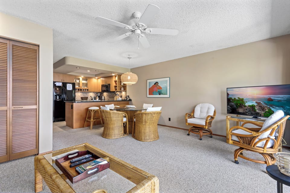Relax in your open-concept living space with coastal-inspired rattan seating, ocean-view TV, and a fully equipped kitchen—perfect for preparing meals and unwinding together after a day of island adventures.